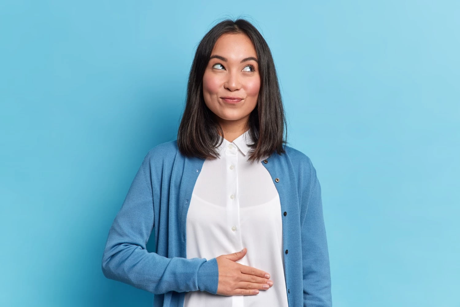 Pleased Cheerful Asian Woman Keeps Hand Belly Feels Full After Delicious Dinner Dressed Casually Stands Thoughtful
