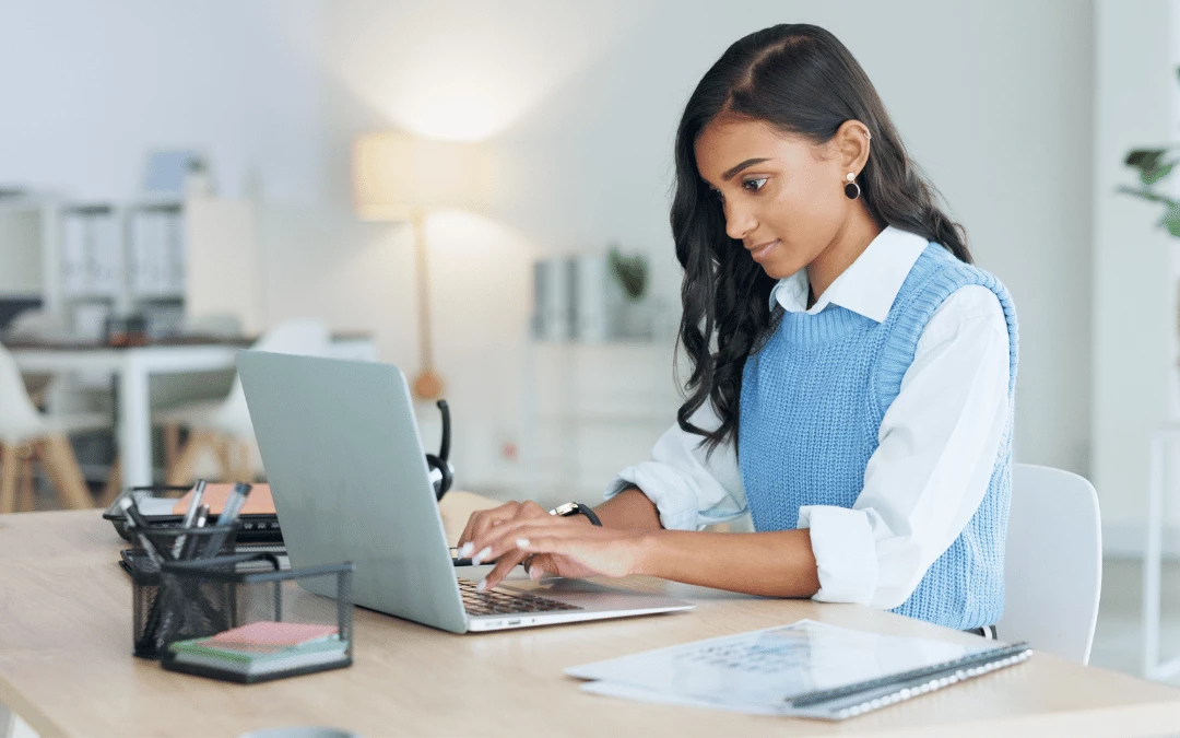 Smiling Woman Typing On Laptop Motivated To Work In Office Desk