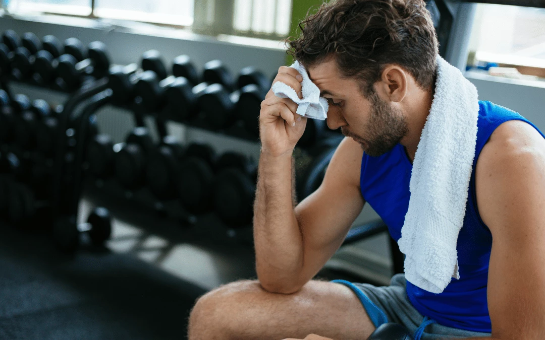 A Man In Gym Clothing Wiping Off His Sweat With A Towel In A Gym Background