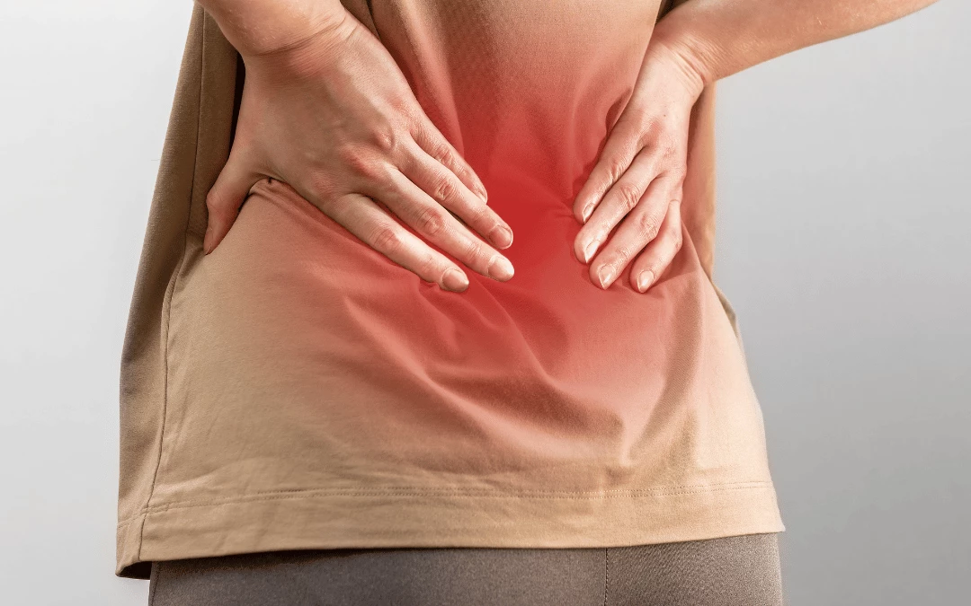 close-up-of-a-woman-back-view-wearing-brown-shirt-with-back-muscle-pain-indicated-with-red-colour-area-with-her-hands-compressing-her-back